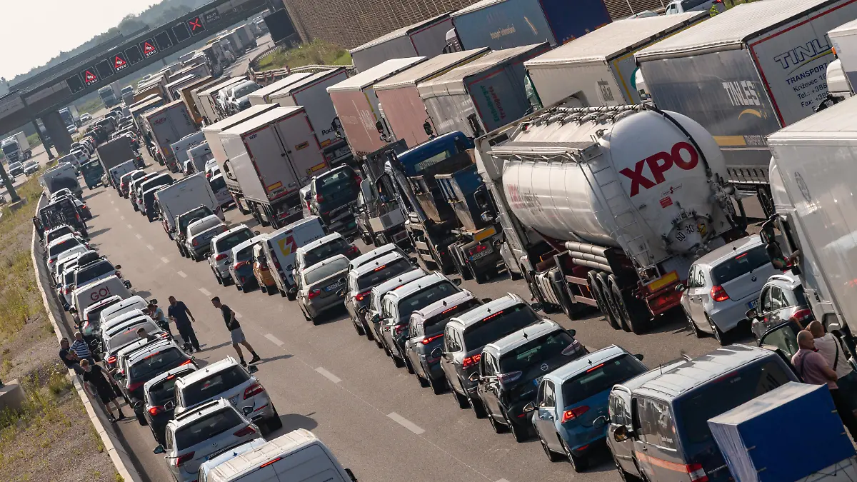 PKW und LKW stehen nach einem Unfall auf der Autobahn A99 dicht an dicht im Stau.