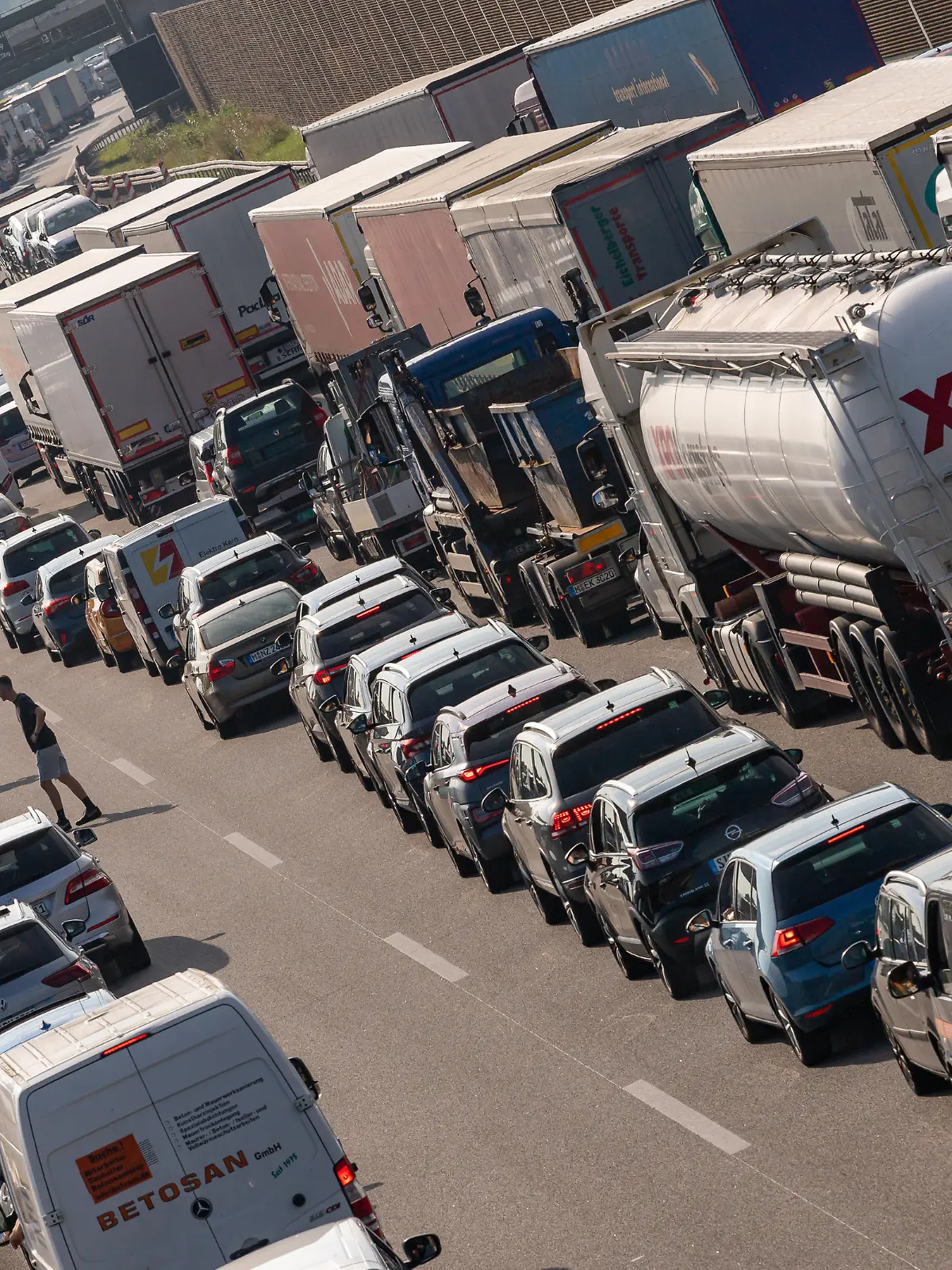 PKW und LKW stehen nach einem Unfall auf der Autobahn A99 dicht an dicht im Stau.