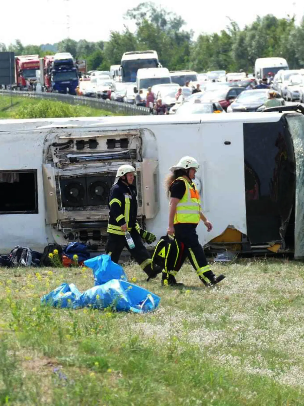 30.07.2021, Brandenburg, Schönwald: Rettungskräfte sind an der Unfallstelle im Einsatz. Auf der Autobahn 13 bei Schönwald (Dahme-Spreewald) südöstlich von Berlin ist ein Reisebus verunglückt. Dabei wurden mehrere Menschen verletzt. Foto: Christian/BLP/dpa +++ dpa-Bildfunk +++