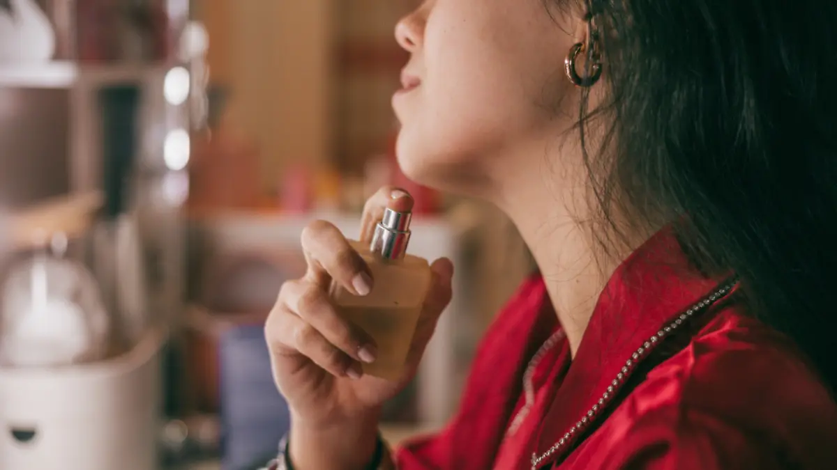 Frau trägt Parfum auf.