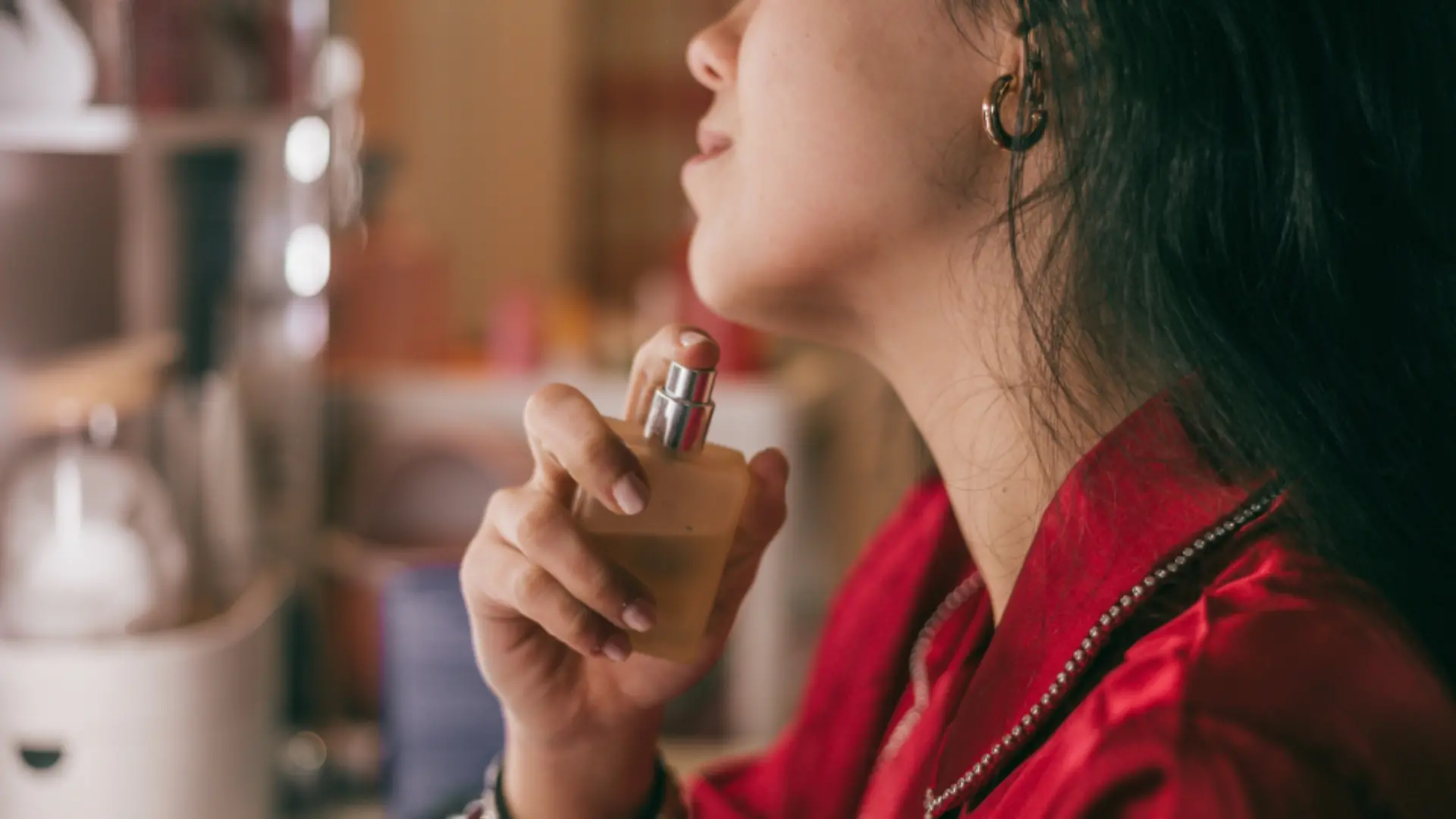 Frau trägt Parfum auf. 