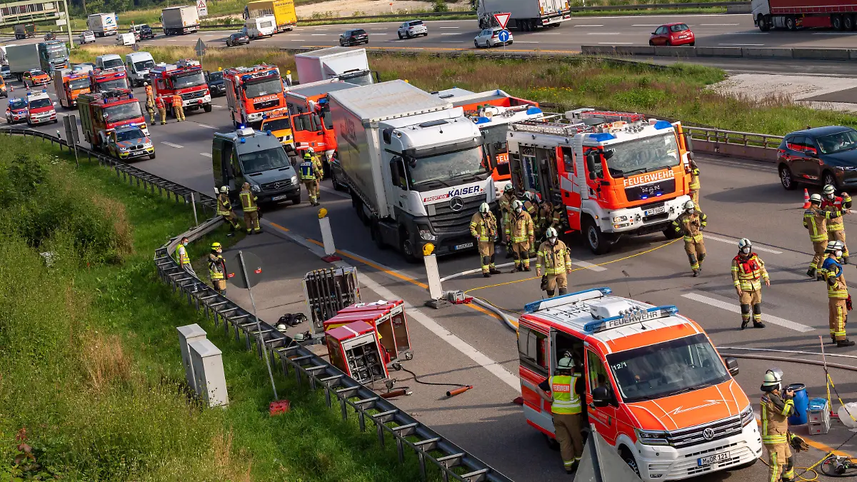 Feuerwehrleute arbeiten auf der Autobahn A99 an einer Unfallstelle, bei der Chemikalien ausgelaufen sind. Der Unfall führte zu einem langen Stau Richtung Süden.