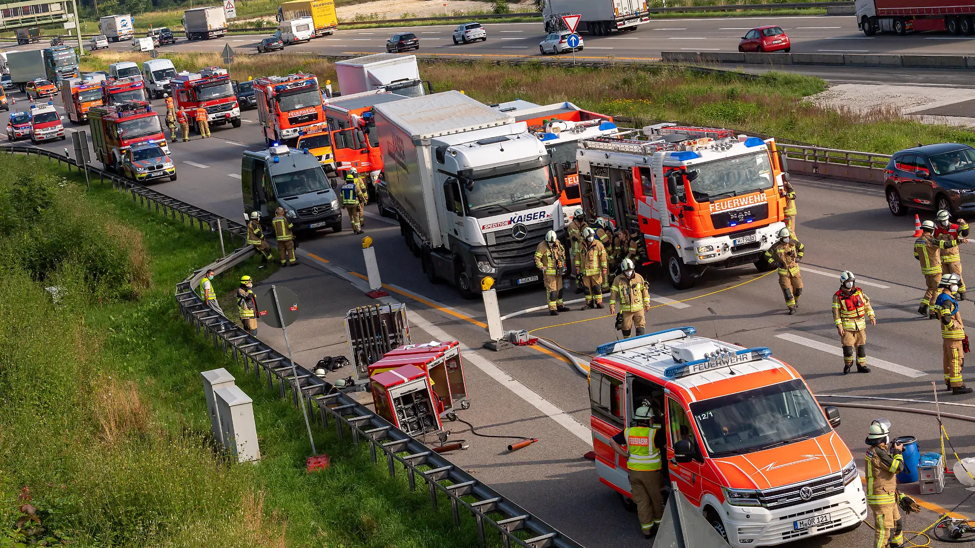 Feuerwehrleute arbeiten auf der Autobahn A99 an einer Unfallstelle, bei der Chemikalien ausgelaufen sind. Der Unfall führte zu einem langen Stau Richtung Süden.