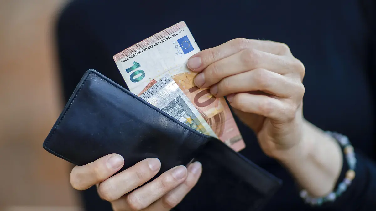 Symbolfoto. Eine Frau nimmt Geldscheine aus einer Geldboerse. Berlin, 06.04.2020. Berlin Deutschland *** Symbol photo A woman takes bank notes from a money exchange Berlin, 06 04 2020 Berlin Germany Copyright: xThomasxTrutschel/photothekx