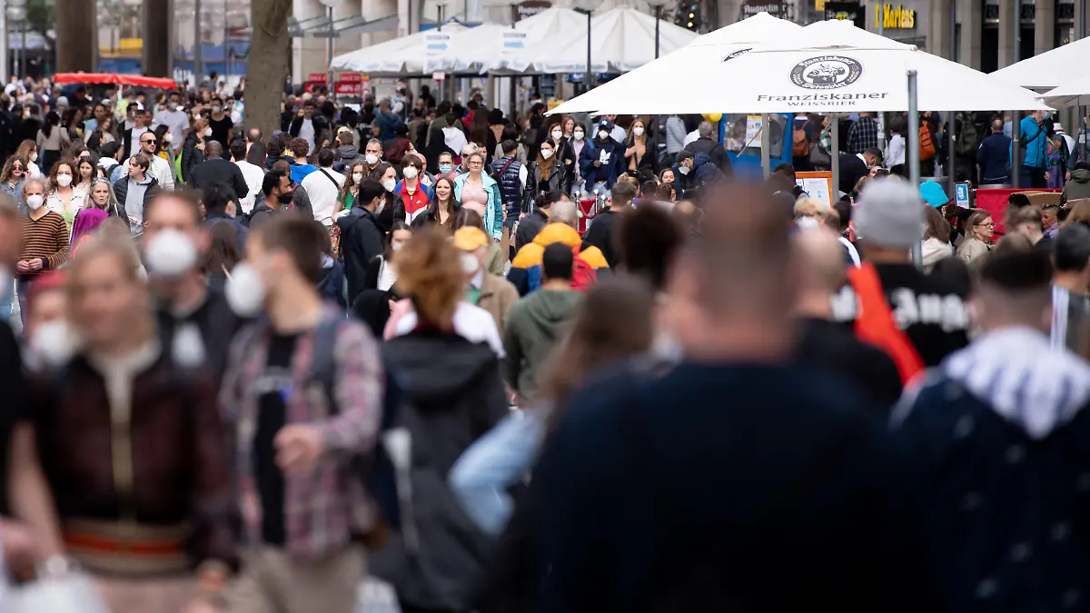 Zahlreiche Menschen spazieren durch die Fußgängerzone in der Innenstadt.