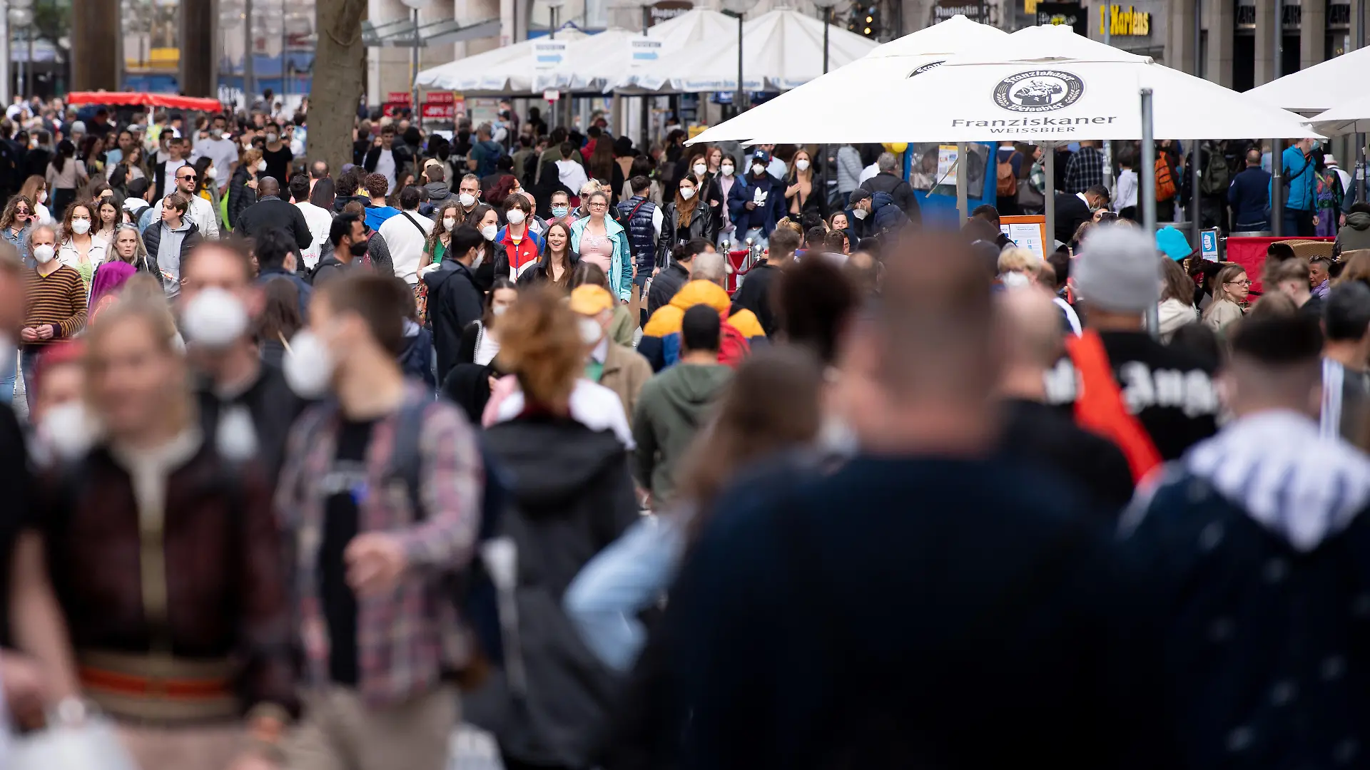 Zahlreiche Menschen spazieren durch die Fußgängerzone in der Innenstadt.