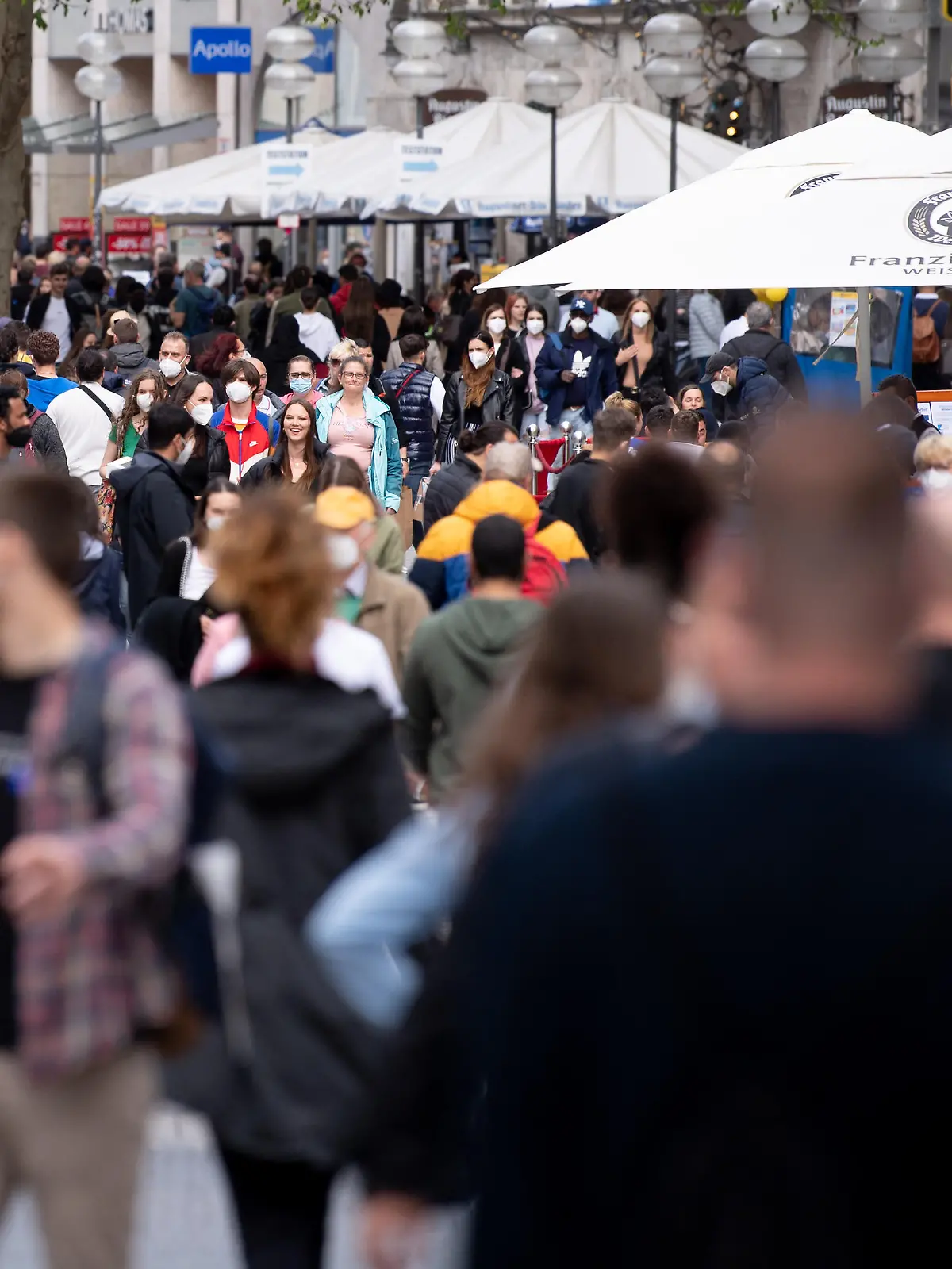 Zahlreiche Menschen spazieren durch die Fußgängerzone in der Innenstadt.