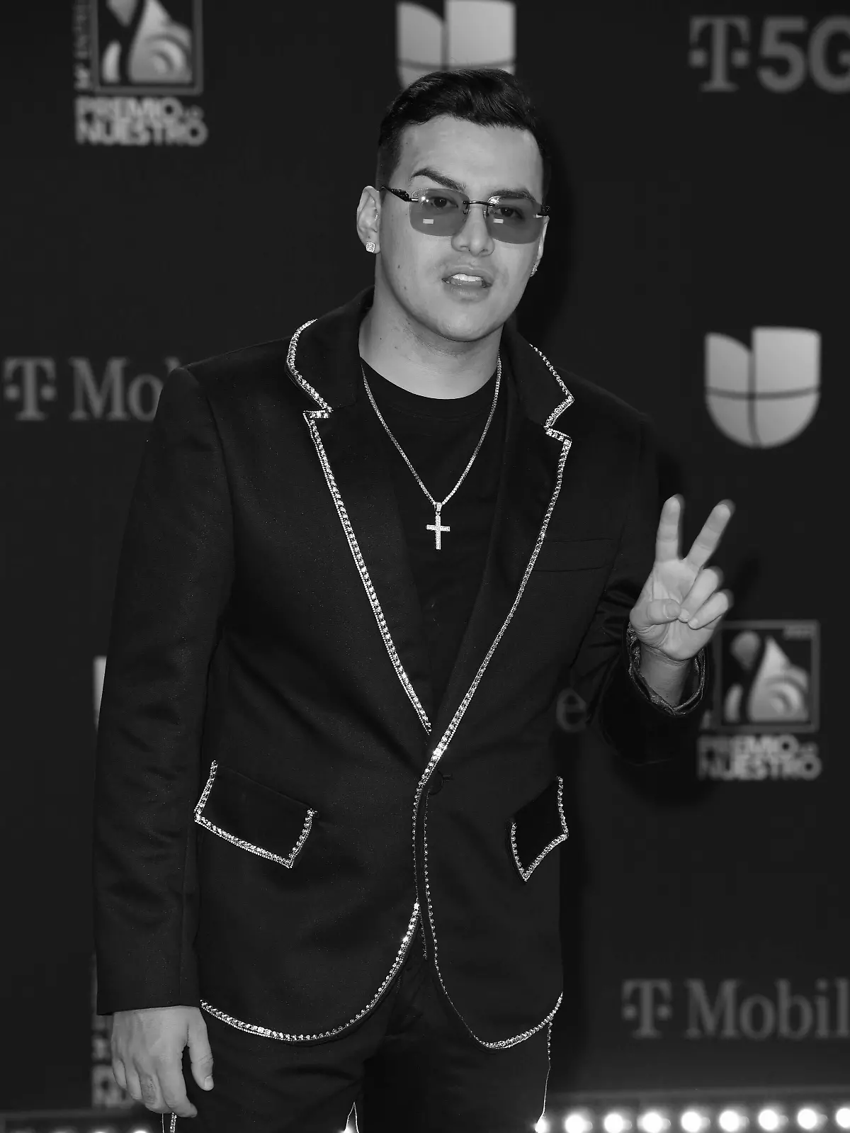 Yeison Jiménez lächelt und zeigt das „Peace”-Zeichen.