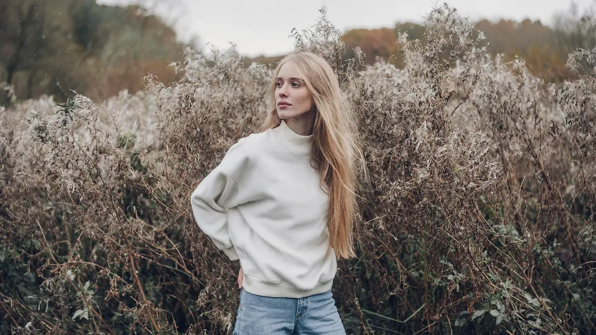 Frau trägt einen weißen Pullover.