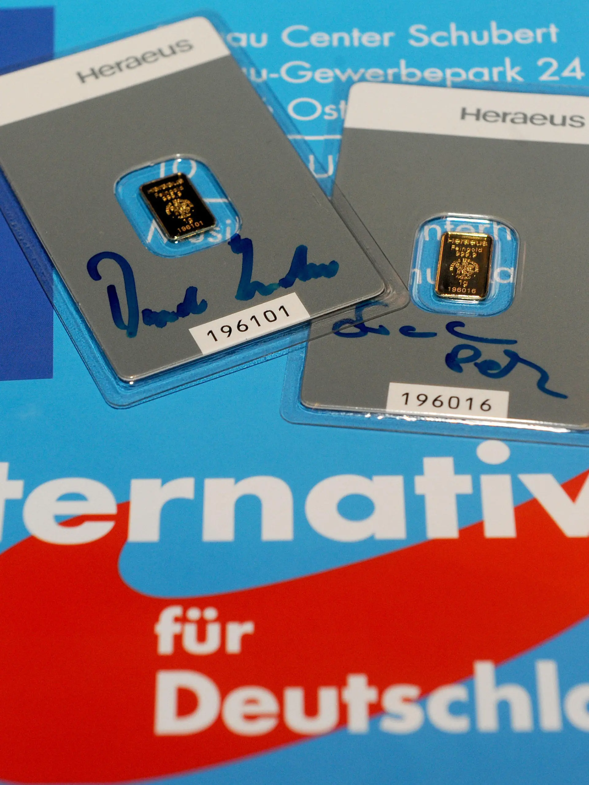 ARCHIV - ILLUSTRATION - Am Rande des 3. Bundesparteitages der Alternative für Deutschland (AfD) in Bremen, liegen am 01.02.2015 zwei jeweils ein Gramm schwere Goldbarren mit den Autogrammen von Frauke Petry (l) und dem früheren Vorsitzenden Bernd Lucke, auf einem Veranstaltungsplakat. Foto: Ingo Wagner/dpa (zu dpa: «Streit um Parteifinanzen: Lex AfD oder Gesetz mit Haarwasser-Effekt? » vom 15.12.2015) +++(c) dpa - Bildfunk+++