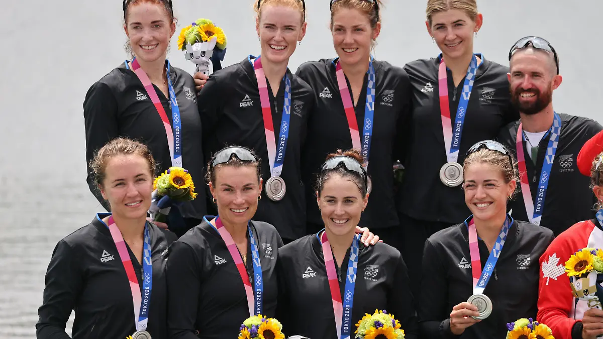 30.07.2021, Japan, Tokio: Rudern: Olympia, Achter mit Steuerfrau, Frauen, Finale im Sea Forest Waterway. Neuseeland (Ella Greenslade, Emma Dyke, Lucy Spoors, Kelsey Bevan, Grace Prendergast, Kerri Gowler, Elizabeth Ross, Jackie Gowler, Caleb Shepherd) jubelt mit Siegerehrung bei der Siegerehrung. Foto: Jan Woitas/dpa-Zentralbild/dpa +++ dpa-Bildfunk +++