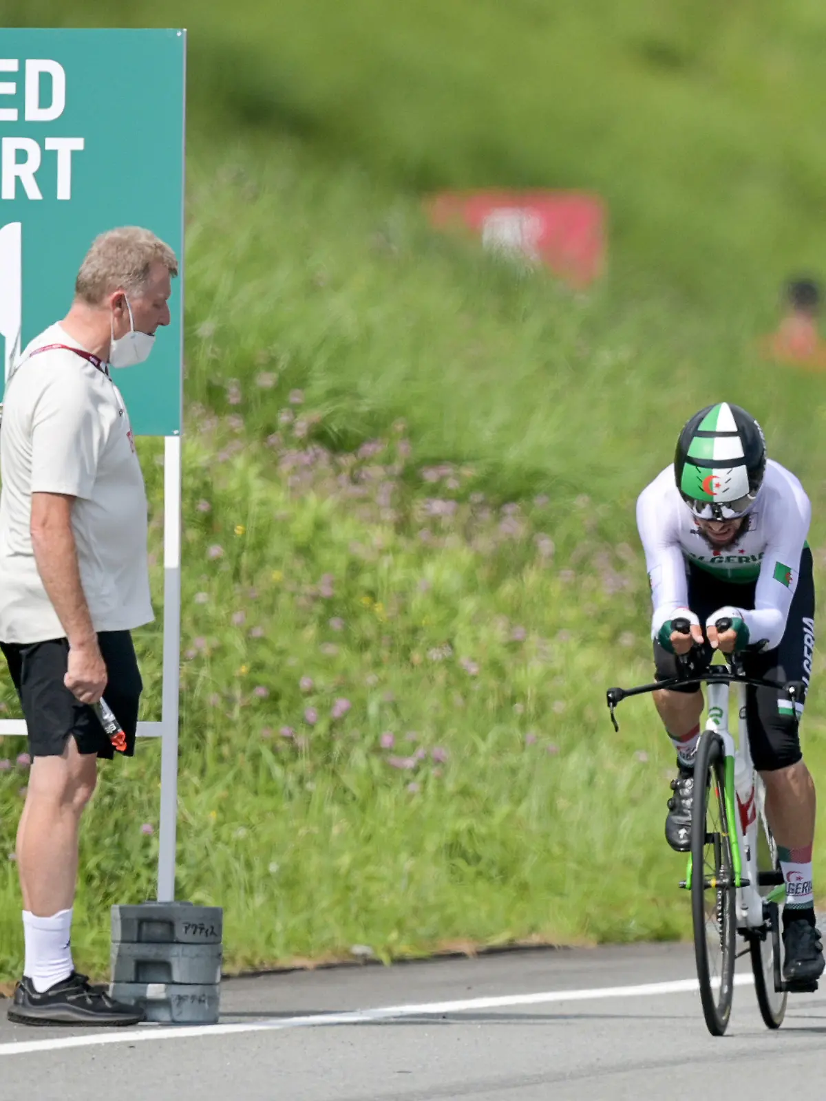 dpatopbilder - 28.07.2021, Japan, Oyama: Radsport: Olympia, Oyama (22,10 km), Männer, Einzelzeitfahren auf dem Fuji International Speedway. Patrick Moster, Sportdirektor vom BDR (Bund Deutscher Radfahrer), steht am Streckenrand neben Azzedine Lagab aus Algerien in Aktion beim Zeitfahren. Foto: Sebastian Gollnow/dpa +++ dpa-Bildfunk +++