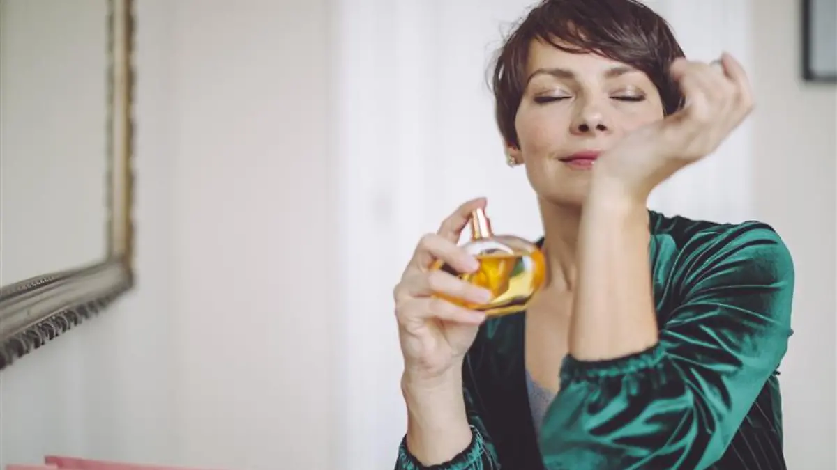 Frau trägt Parfum auf.