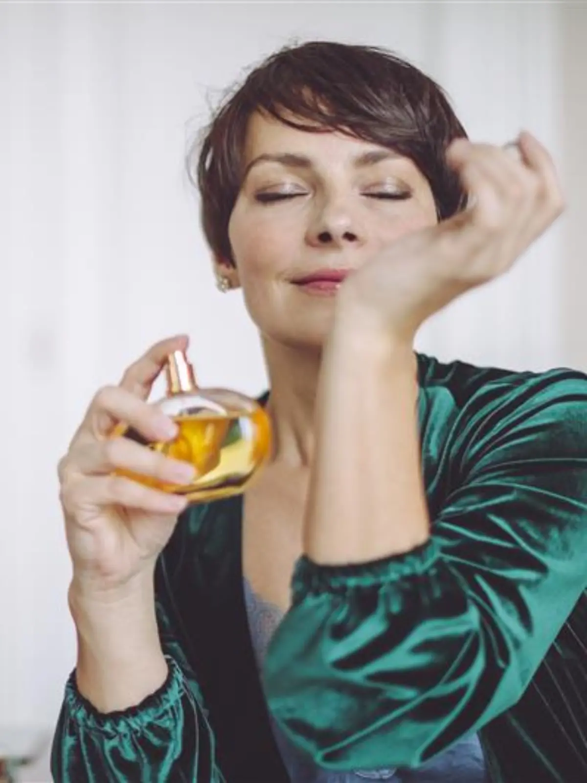 Frau trägt Parfum auf.