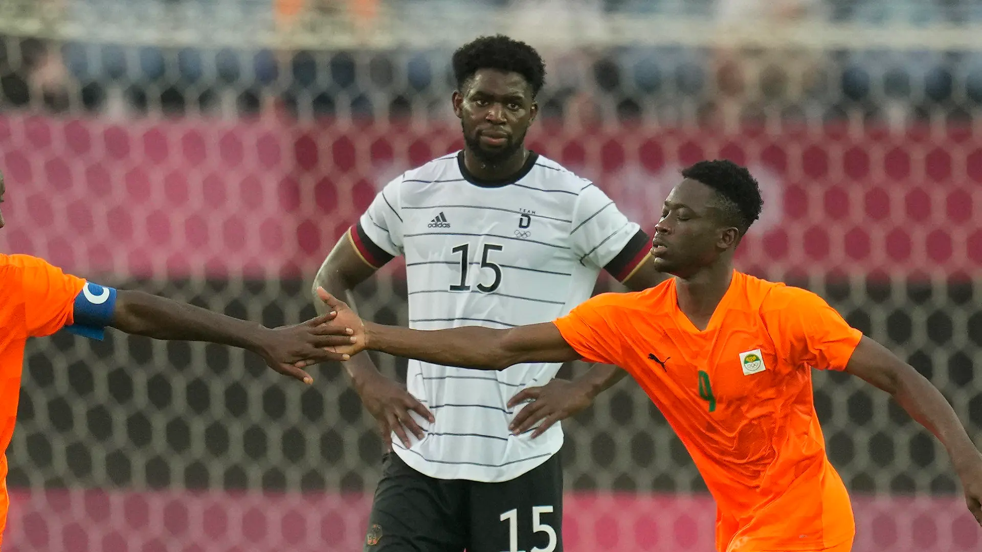 Ivory Coast's Max Gradel, left, and Youssouf Dao, right, celebrate after Germany's Benjamin Henrichs scored an own goal during a men's soccer match at the 2020 Summer Olympics, Wednesday, July 28, 2021, in Rifu, Japan. Germany's Jordan Torunarigha (15) looks on. (AP Photo/Andre Penner)