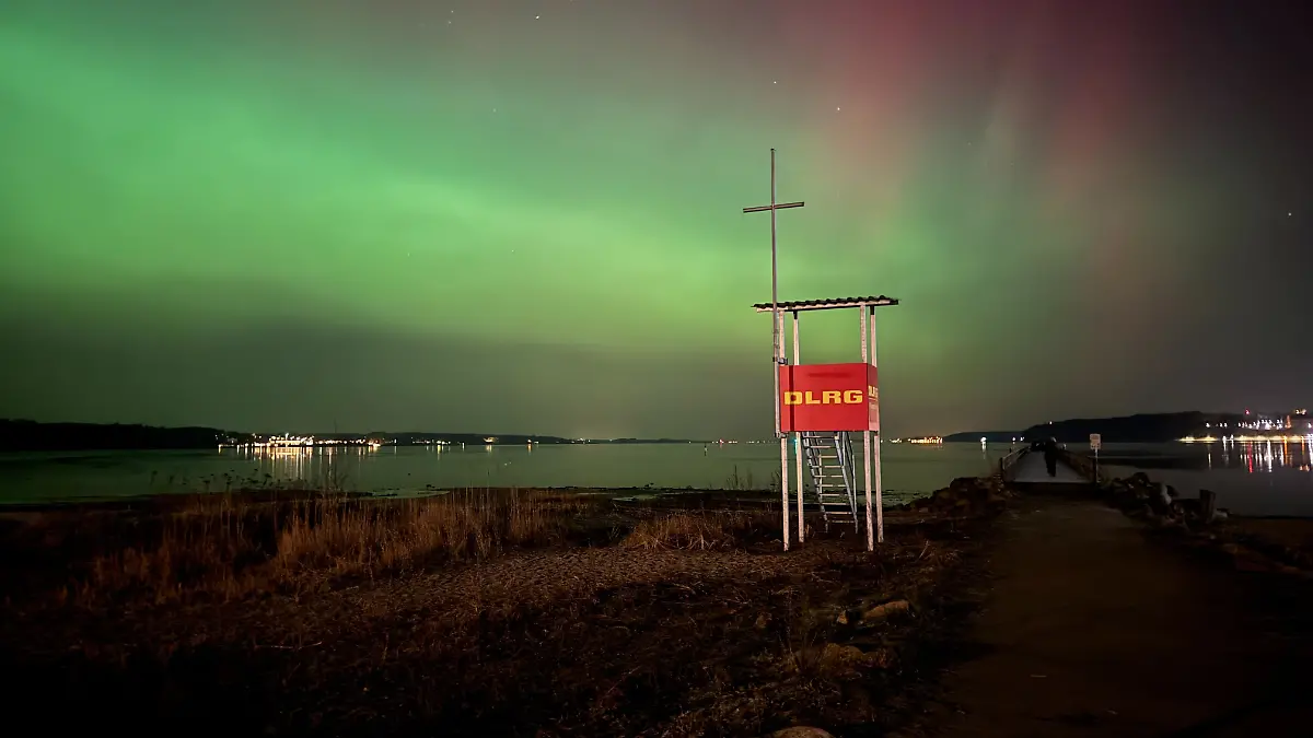 Polarlichter leuchten am Nachthimmel über der Flensburger Förde. 