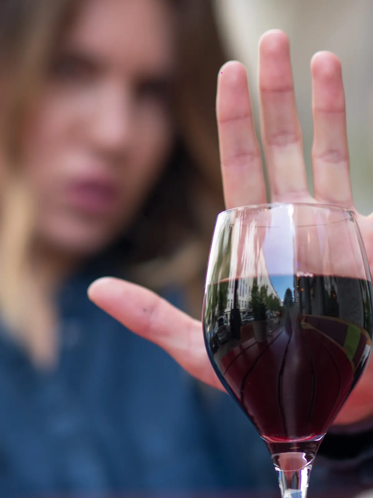 Junge Frau lehnt ein Glas Wein ab (Symbolfoto) 