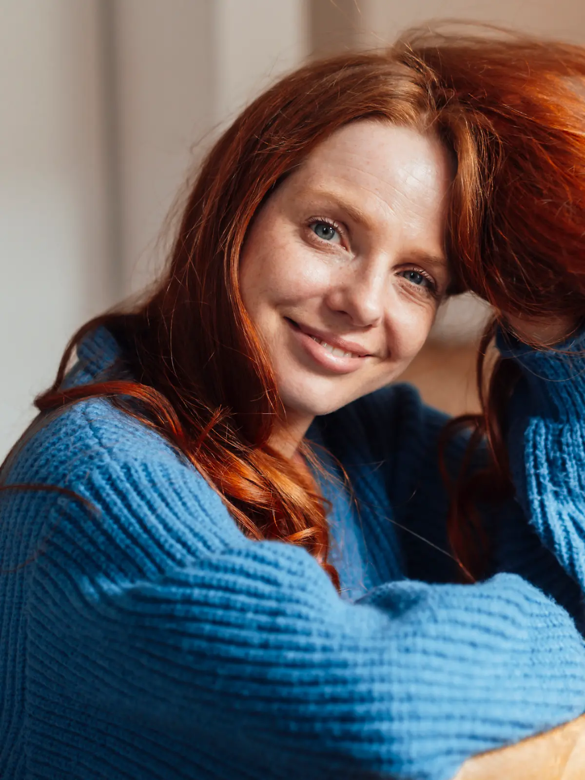 Frau trägt einen blauen Cardigan.