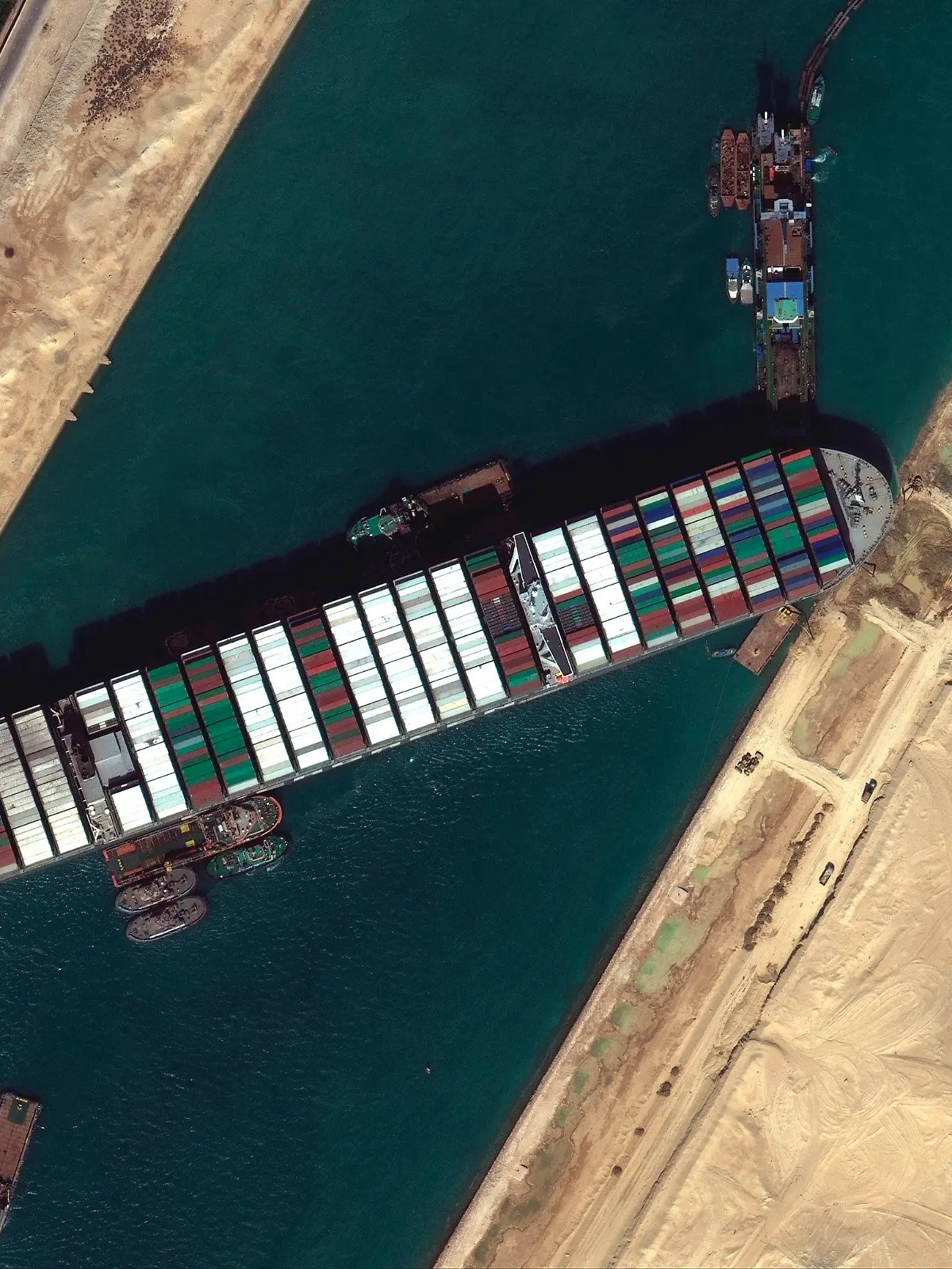 HANDOUT - 27.03.2021, Ägypten, Suez: Ein Satellitenbild zeigt das festgesetzte Containerschiff «Ever Given» im Suezkanal, das die wichtige Schifffahrtsstraße zwischen Asien und Europa blockiert. Die erhoffte Freilegung des Schiffs schreitet in kleinen Schritten voran. Foto: Uncredited/©Maxar Technologies/AP/dpa - ACHTUNG: Nur zur redaktionellen Verwendung im Zusammenhang mit der aktuellen Berichterstattung und nur mit vollständiger Nennung des vorstehenden Credits +++ dpa-Bildfunk +++