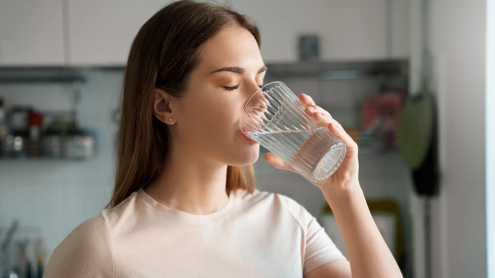 Junge Frau trinkt ein Glas Wasser