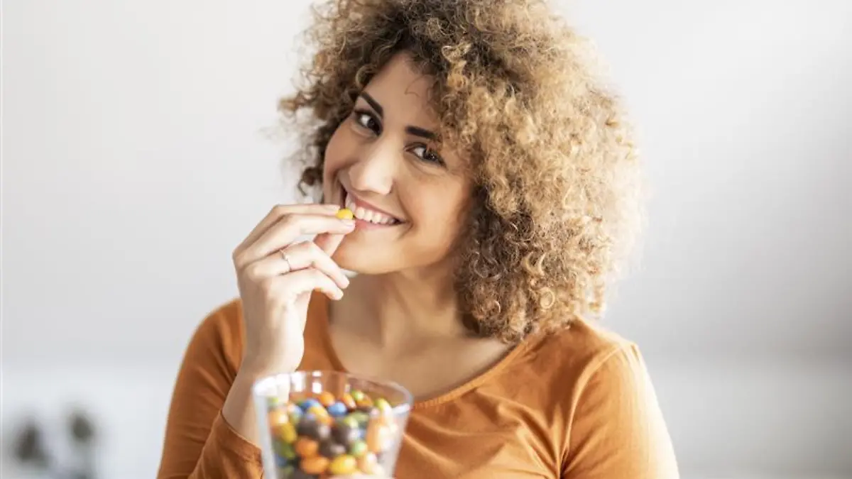 Frau nascht Süßigkeiten.