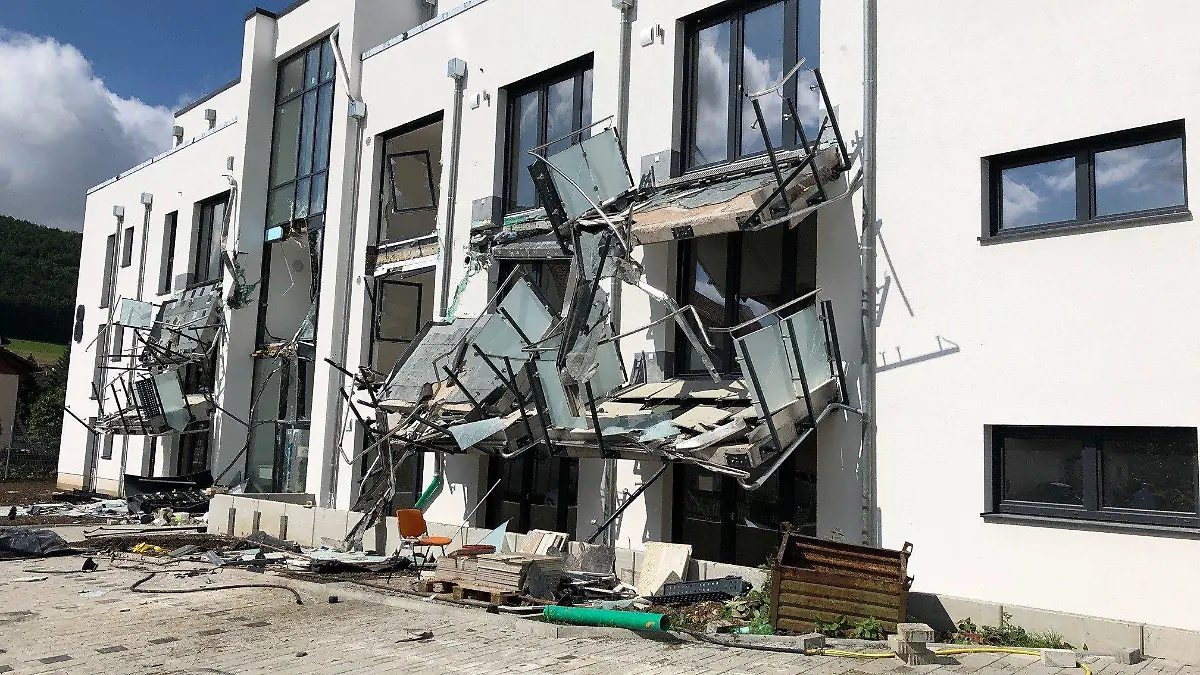 HANDOUT - 29.07.2021, Baden-Württemberg, Blumberg: Ein Neubau mit heruntergerissenen Balkonen und zerstörter Fassade. Nach Angaben der Polizei soll ein Bauunternehmer aus Ärger über zurückgehaltene Zahlungen der Auftraggeber mit einem Bagger das Gebäude mutwillig mit einem Bagger beschädigt haben. (Zu dpa: «Frust über ausstehende Zahlungen: Baggerfahrer zerlegt Neubau») Foto: Hardy Faißt/SWR/dpa - ACHTUNG: Nur zur redaktionellen Verwendung im Zusammenhang mit der aktuellen Berichterstattung und nur mit vollständiger Nennung des vorstehenden Credits +++ dpa-Bildfunk +++