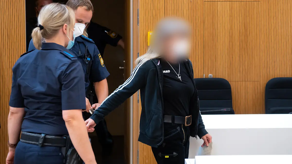 Der wegen Vorbereitung einer schweren staatsgefährdenden Gewalttat Angeklagten (r) werden im Sitzungssaal die Handschellen abgenommen. Weil sie Politiker bedroht und einen Brandanschlag vorbereitet hat, muss die Rechtsterroristin aus Franken für sech