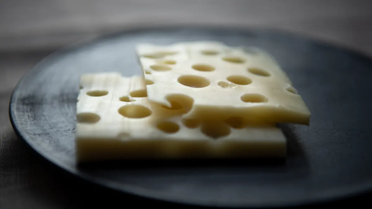 Eine Edamer liegt auf einem Holzbrett.