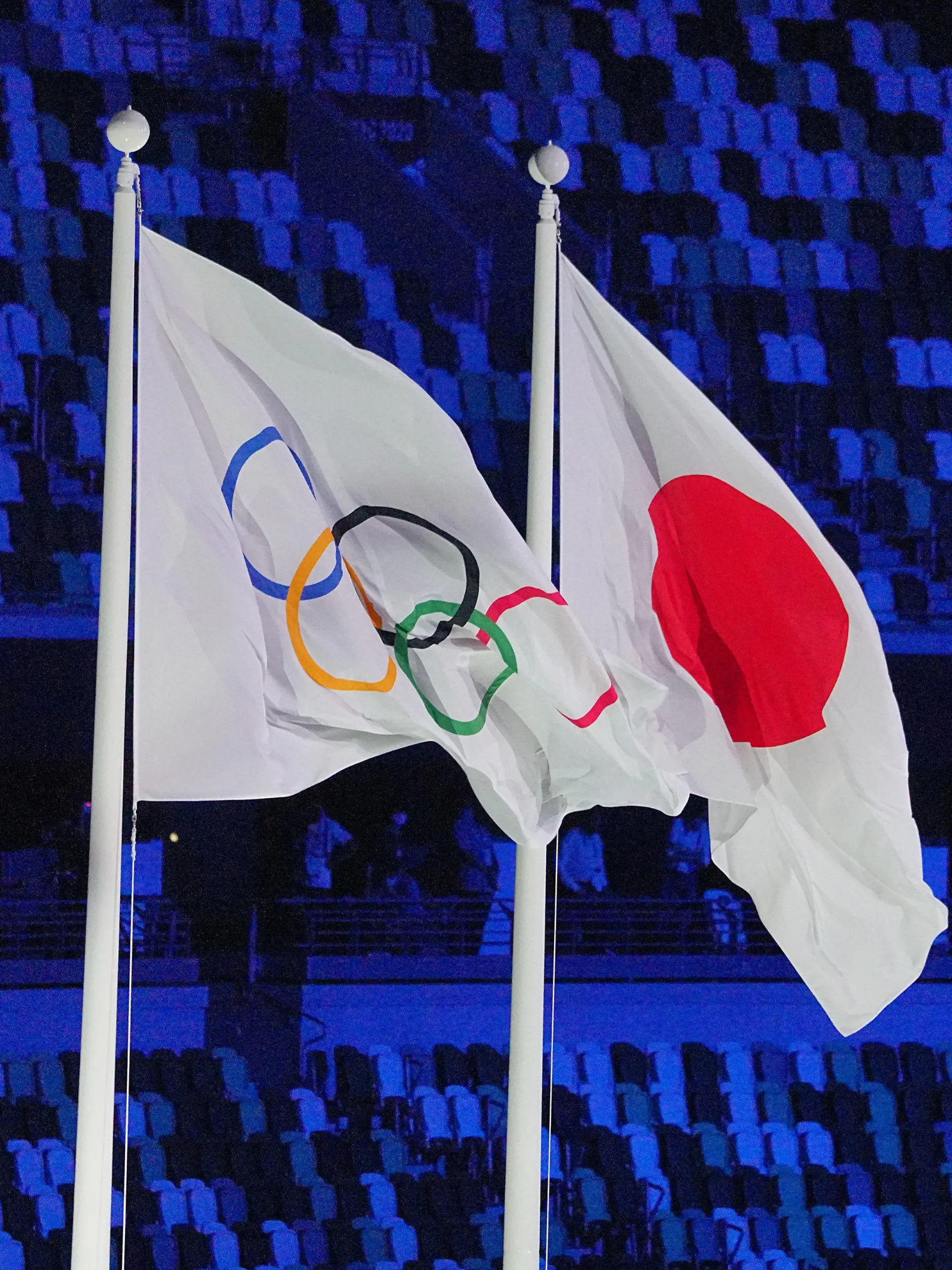 dpatopbilder - 23.07.2021, Japan, Tokio: Olympia: Eröffnungsfeier im Olympiastadion. Die Olympische Flagge weht neben der Japanischen Flagge. Foto: Michael Kappeler/dpa +++ dpa-Bildfunk +++