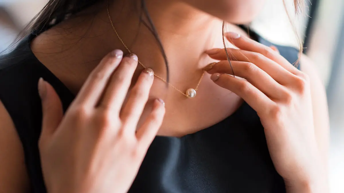 Frau trägt Perlenkette