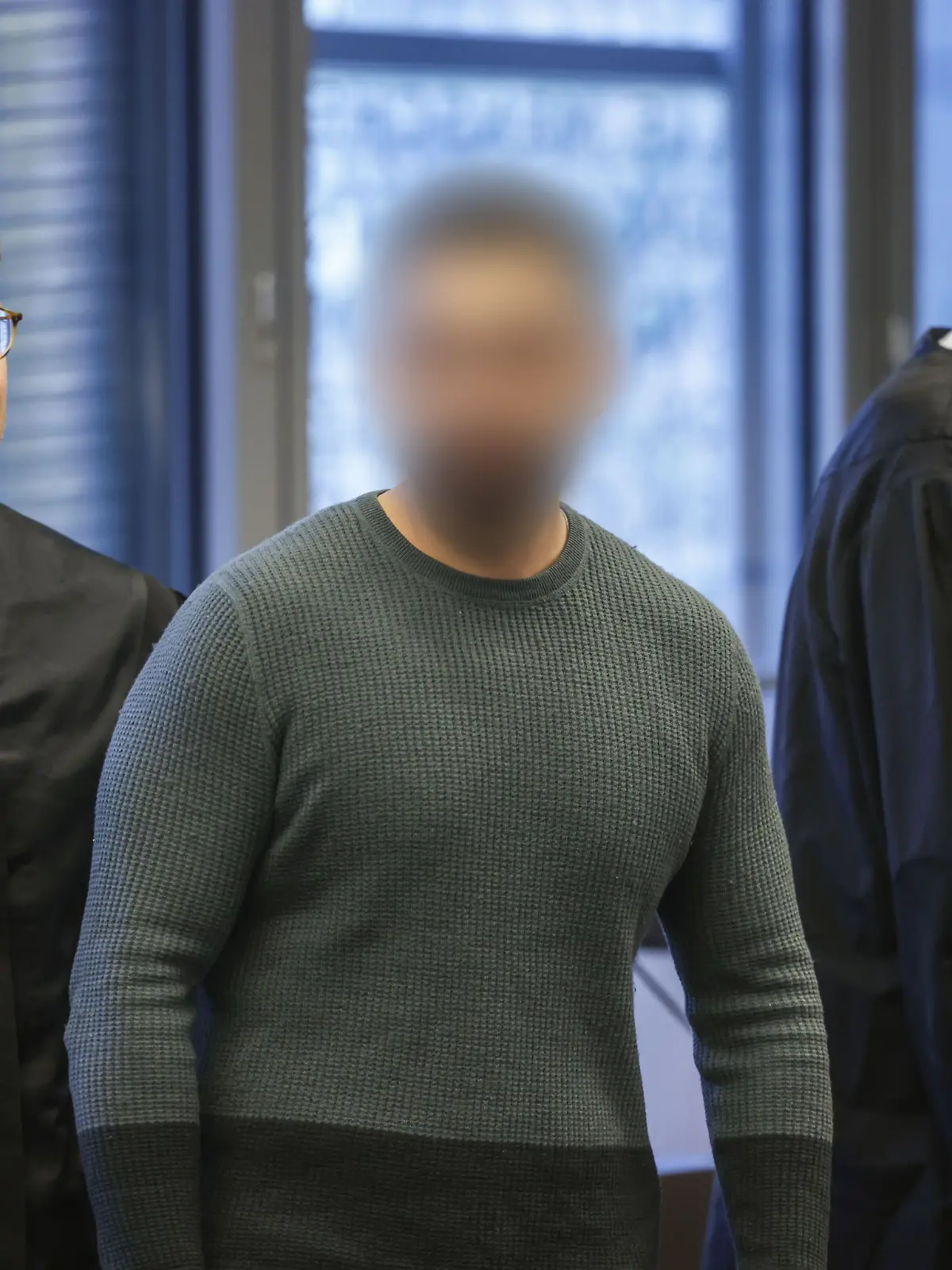 Der Angeklagte (M) mit seinen Anwältenbeim Prozessauftakt.