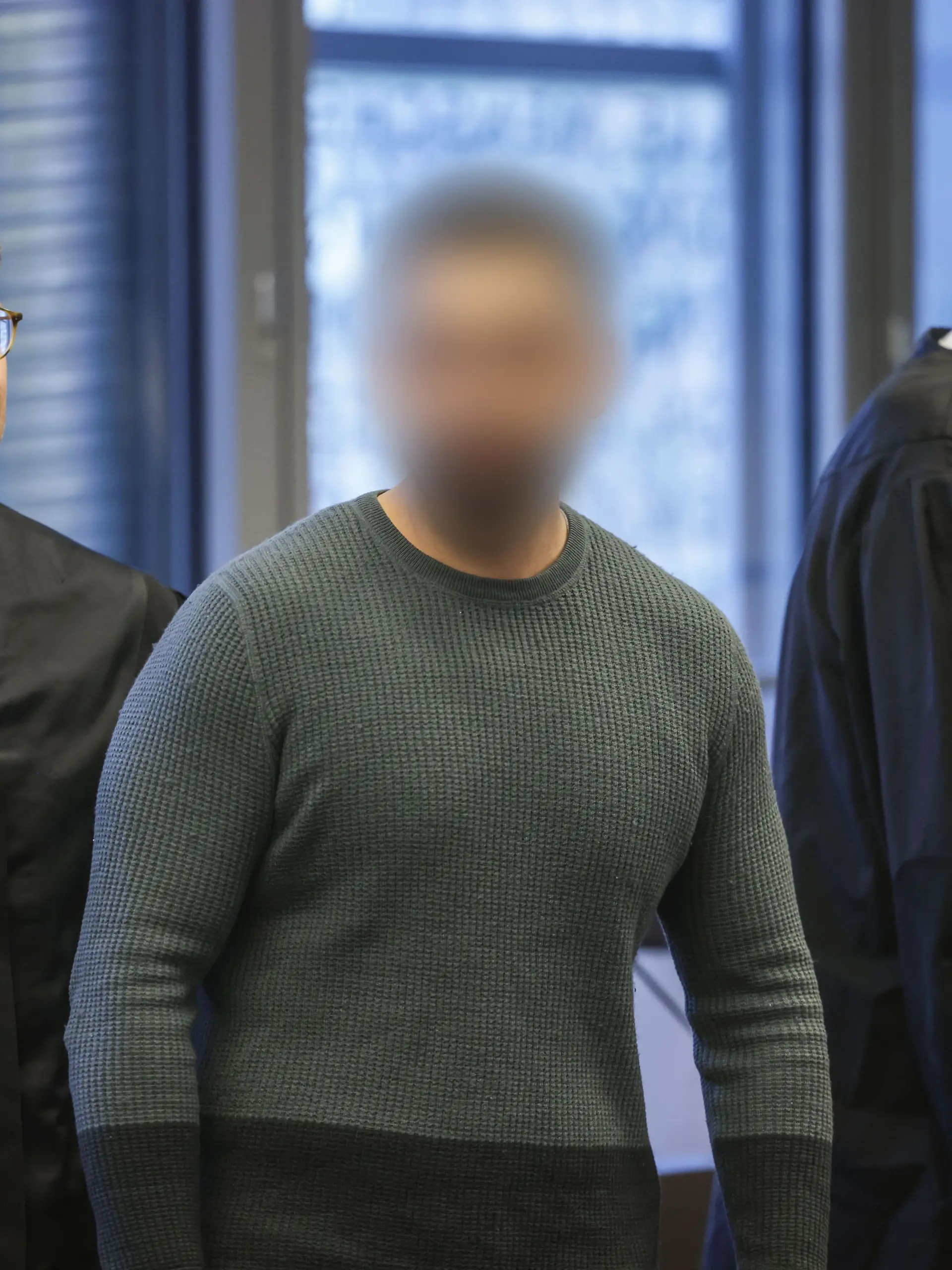 Der Angeklagte (M) mit seinen Anwältenbeim Prozessauftakt.