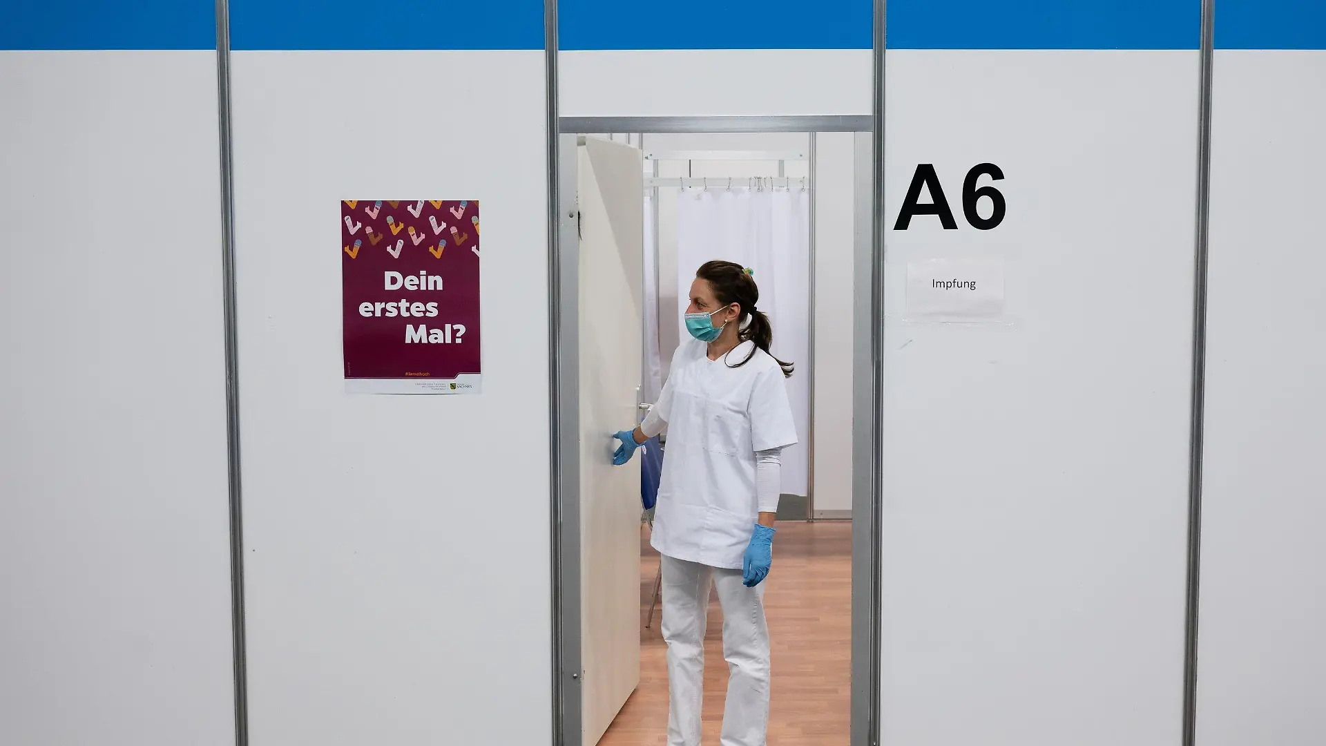 23.07.2021, Sachsen, Löbau: Melanie Ruoff, Impfhelferin, steht im Impfzentrum Löbau vor einer leeren Impfkabine. Sachsens Ministerpräsident Kretschmer hat am gleichen Tag das Impfzentrum besucht um sich über die aktuelle Situation zu informieren. Foto: Sebastian Kahnert/dpa-Zentralbild/dpa +++ dpa-Bildfunk +++