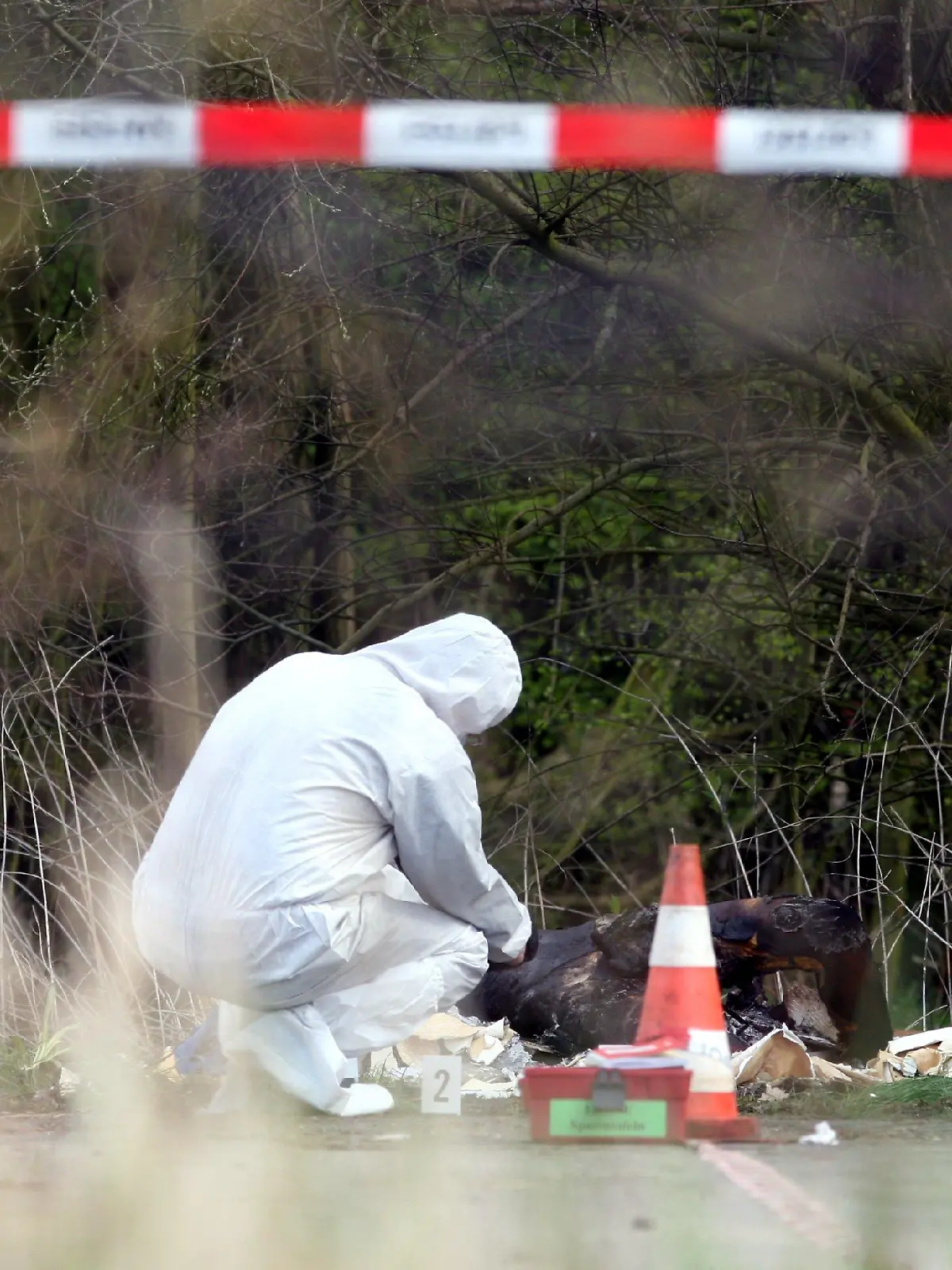 Beamte der Hamburger Polizei suchen am Mittwoch (16.04.2008) neben einem verbrannten Menschen im Stadtteil Moorfleet nach Spuren. Der Hintergrund des Leichenfunds ist noch unklar. Bislang sind keine näheren Einzelheiten bekannt. Die Beamten der Mordkommission haben am Fundort die Ermittlungen übernommen. Foto: Kay Nietfeld dpa/lno +++(c) dpa - Bildfunk+++