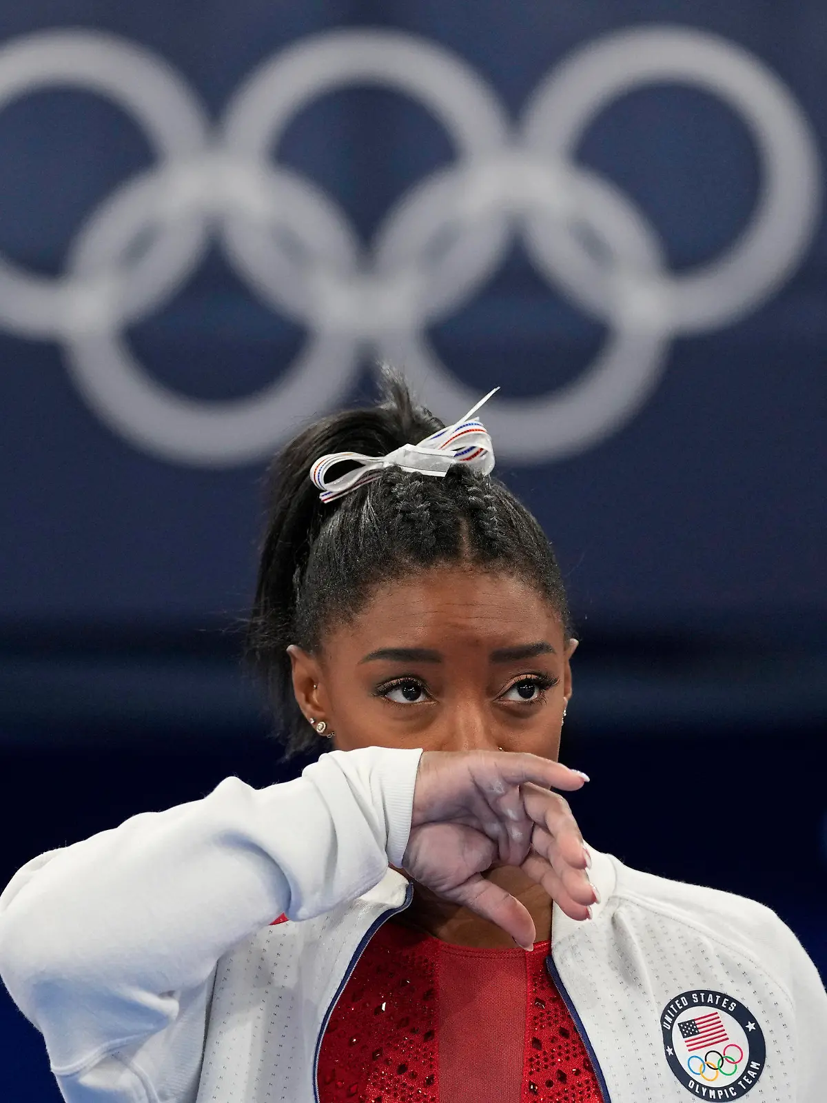 Simone Biles, of the United States, watches gymnasts perform at the 2020 Summer Olympics, Tuesday, July 27, 2021, in Tokyo. Biles says she wasn't in right 'headspace' to compete and withdrew from gymnastics team final to protect herself. (AP Photo/Ashley Landis)