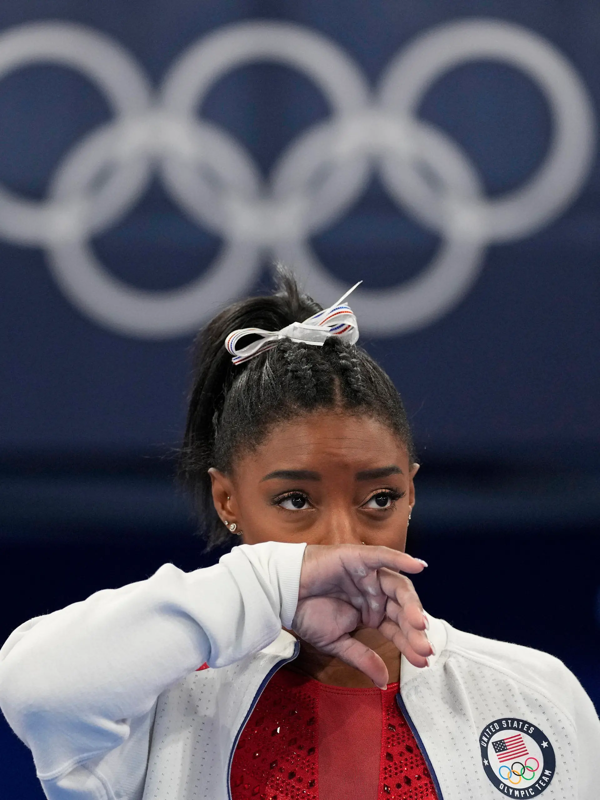 Simone Biles, of the United States, watches gymnasts perform at the 2020 Summer Olympics, Tuesday, July 27, 2021, in Tokyo. Biles says she wasn't in right 'headspace' to compete and withdrew from gymnastics team final to protect herself. (AP Photo/Ashley Landis)