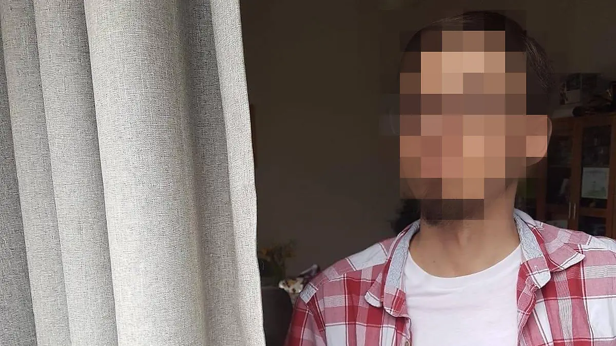Mann in karrierten Hemd. Gesicht unkenntlich gemacht.