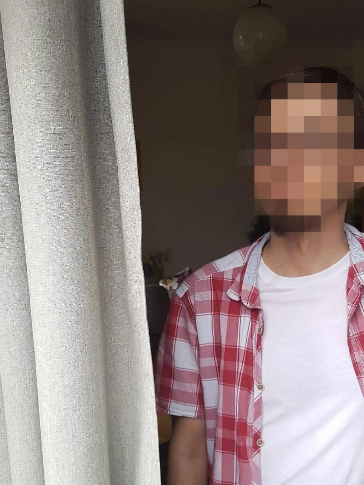 Mann in karrierten Hemd. Gesicht unkenntlich gemacht.