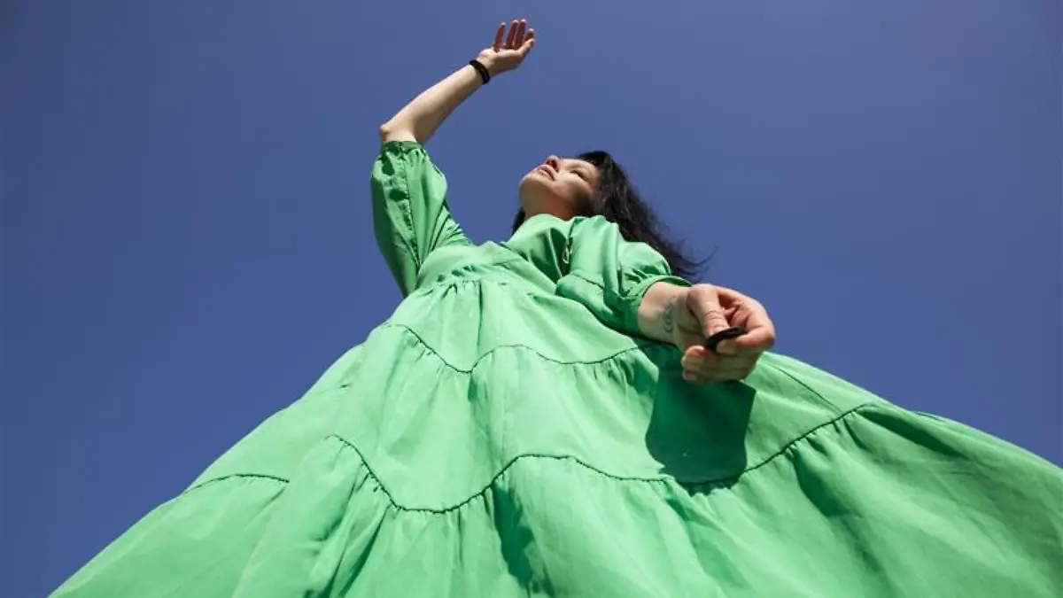 Frau trägt ein grünes Kleid.