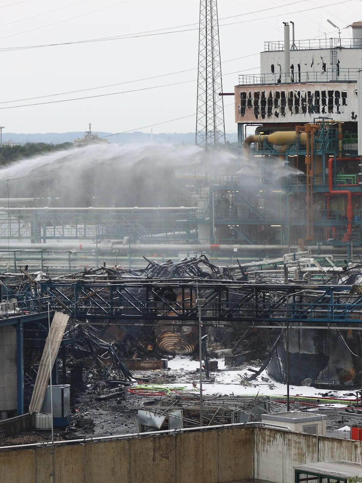 HANDOUT - 28.07.2021, Nordrhein-Westfalen, Leverkusen: Einsatzkräfte der Feuerwehr sind mit Löscharbeiten im Chempark beschäftigt. Nach der Explosion in einer Müllverbrennungsanlage am Vortag geht die Suche nach den Vermissten weiter. Foto: Chempark/Currenta GmbH - ACHTUNG: Nur zur redaktionellen Verwendung im Zusammenhang mit der aktuellen Berichterstattung und nur mit vollständiger Nennung des vorstehenden Credits +++ dpa-Bildfunk +++