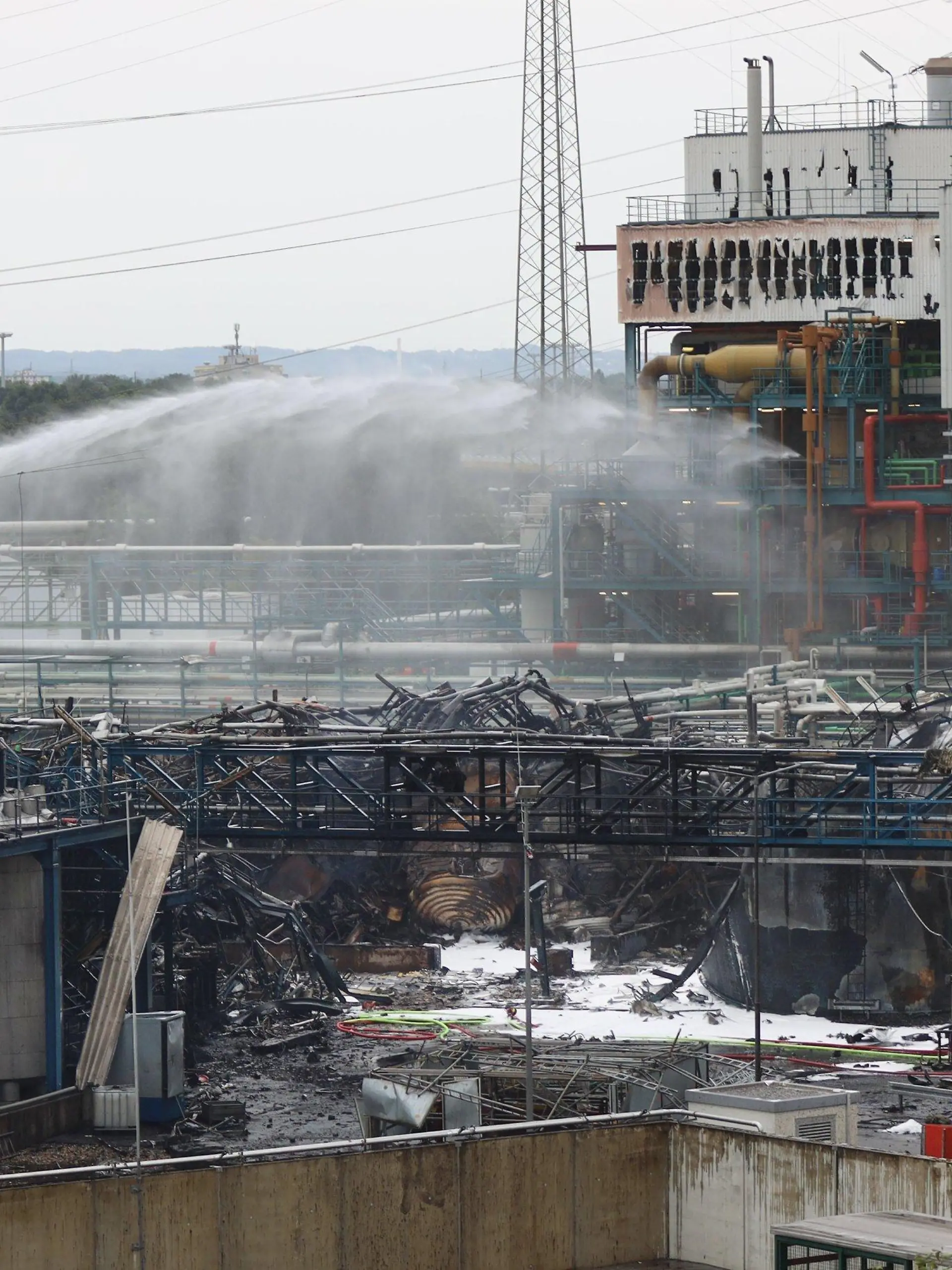 HANDOUT - 28.07.2021, Nordrhein-Westfalen, Leverkusen: Einsatzkräfte der Feuerwehr sind mit Löscharbeiten im Chempark beschäftigt. Nach der Explosion in einer Müllverbrennungsanlage am Vortag geht die Suche nach den Vermissten weiter. Foto: Chempark/Currenta GmbH - ACHTUNG: Nur zur redaktionellen Verwendung im Zusammenhang mit der aktuellen Berichterstattung und nur mit vollständiger Nennung des vorstehenden Credits +++ dpa-Bildfunk +++