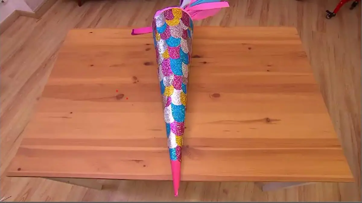 Meerjungfrauen-Schultüte mit DIY gebastelt liegt auf einem Holzboden.