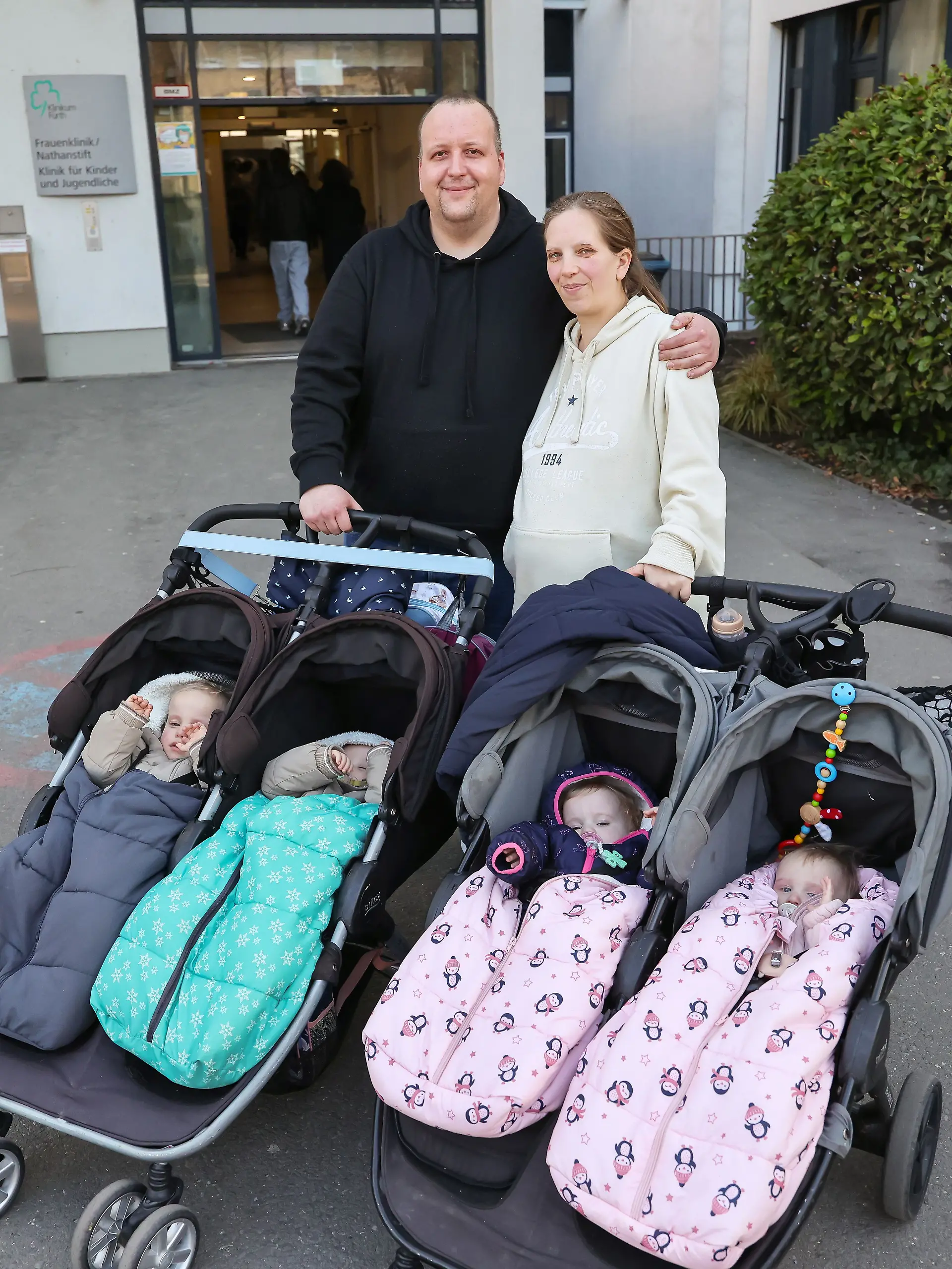 Andreas Rittner (l) und Jasmin Schmidt (r) verlassen mit ihren vier Kindern das Klinikum Fürth. Die Familie erwartet jetzt zum dritten Mal Zwillinge. 