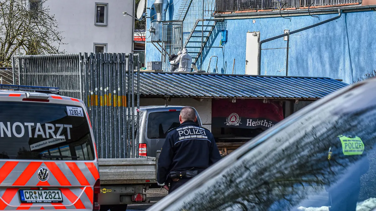 10.02.2026, Baden-Württemberg, Schrozberg: Polizisten in Spezialanzügen (hinten) stehen bei der Spurensicherung an der Rückseite eines Wohn- und Geschäftshauses, an dem ein Mann seine Frau erschossen haben soll. Wie die Polizei mitteilte, gab der Mann mehrere Schüsse auf die Frau ab. Der Mann konnte wenig später von der Polizei festgenommen werden. Foto: Fabian Koss/onw-images/dpa - ACHTUNG: Ein Kennzeichen wurde aus rechtlichen Gründen gepixelt +++ dpa-Bildfunk +++