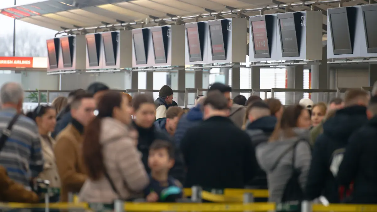 Passagiere stehen am Flughafen Köln/Bonn an Check-in-Schaltern Schlange. Aufgrund eines Sicherheitsvorfalls war der Flugbetrieb auf dem Flughafen Köln/Bonn zeitweise weitgehend eingestellt worden.
