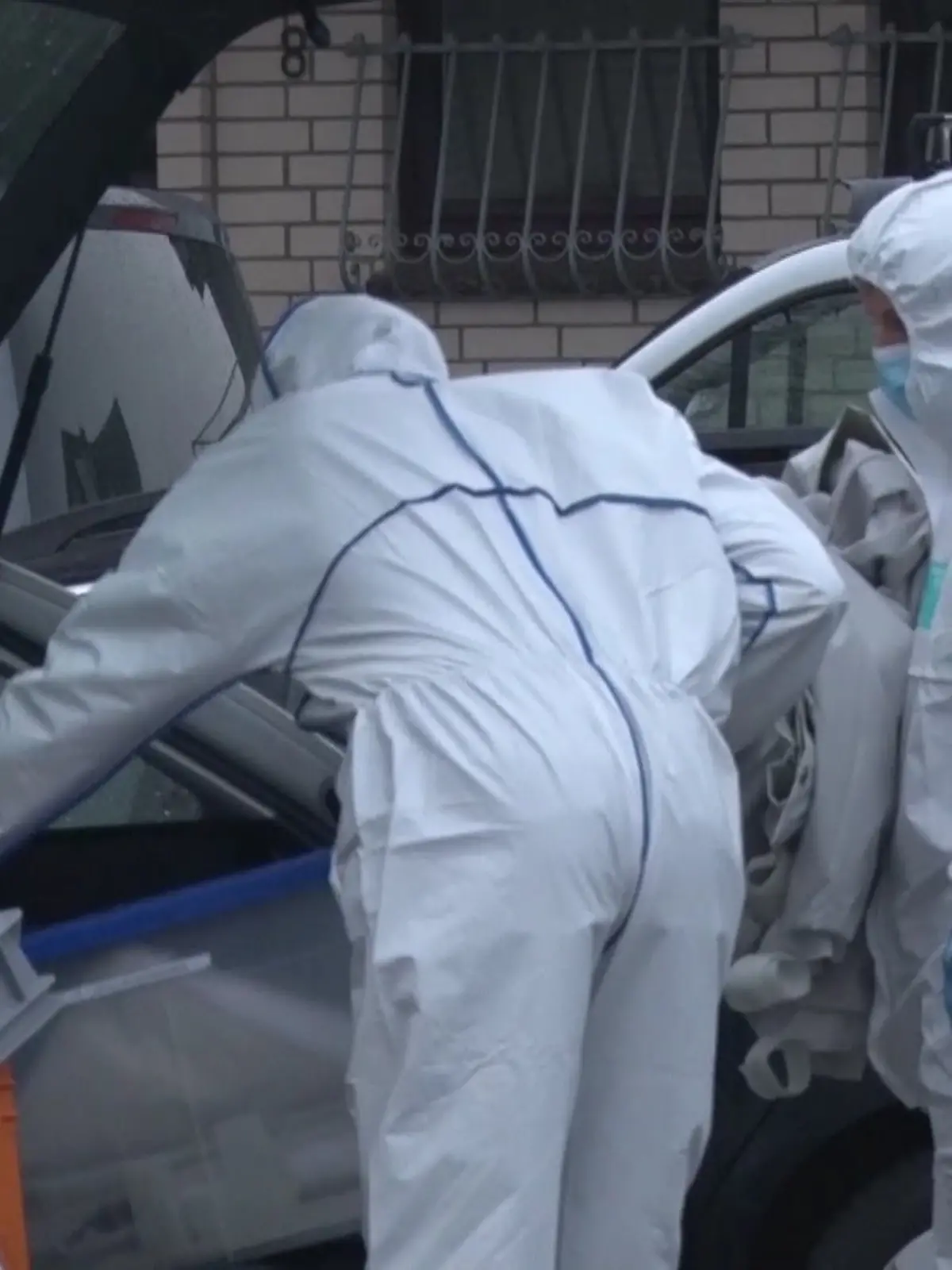 Kriminaltechniker tragen kistenweise Beweismaterial aus dem Haus der Familie.