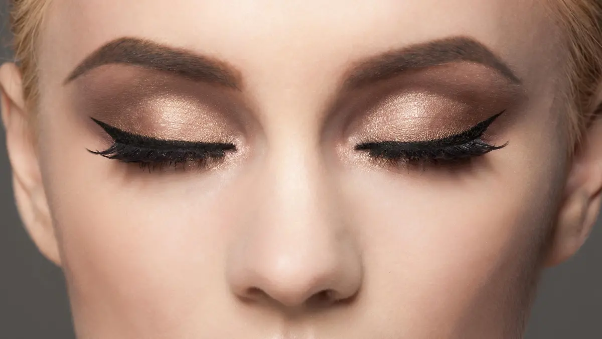 Closeup image of woman closed eyes with beautiful bright makeup. Makeup with eyeliner and falce eyelashes