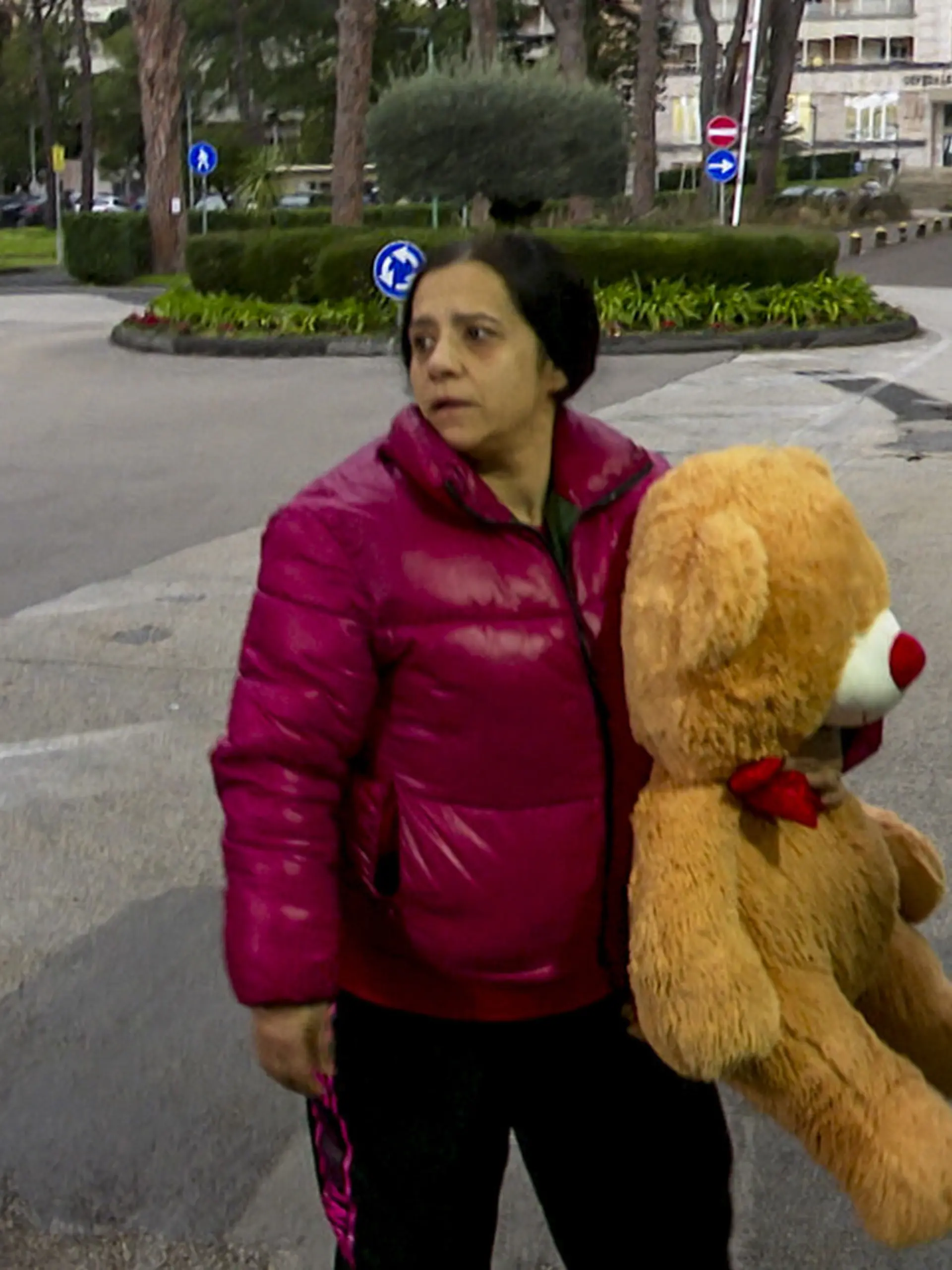 Die Mutter des kleinen Jungen läuft mit einem Kuscheltier zur Klinik. 