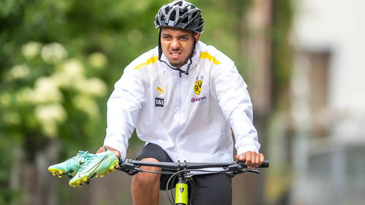 27.07.2021, Schweiz, Bad Ragaz: Fußball: Bundesliga, Trainingslager Borussia Dortmund auf dem Sportplatz Ri-Au. Donyell Malen verlässt auf einem Fahrrad das Trainingsgelände. Am Dienstagvormittag hat der niederländische Nationalspieler von der PSV Eindhoven in Bad Ragaz erstmals am Training des Fußball-Bundesligisten teilgenommen. Der 22-Jährige soll die Lücke schließen, die Jadon Sancho mit seinem 85 Millionen Euro teuren Transfer zu Manchester United hinterlassen hat. Foto: David Inderlied/dpa - WICHTIGER HINWEIS: Gemäß den Vorgaben der DFL Deutsche Fußball Liga bzw. des DFB Deutscher Fußball-Bund ist es untersagt, in dem Stadion und/oder vom Spiel angefertigte Fotoaufnahmen in Form von Sequenzbildern und/oder videoähnlichen Fotostrecken zu verwerten bzw. verwerten zu lassen. +++ dpa-Bildfunk +++