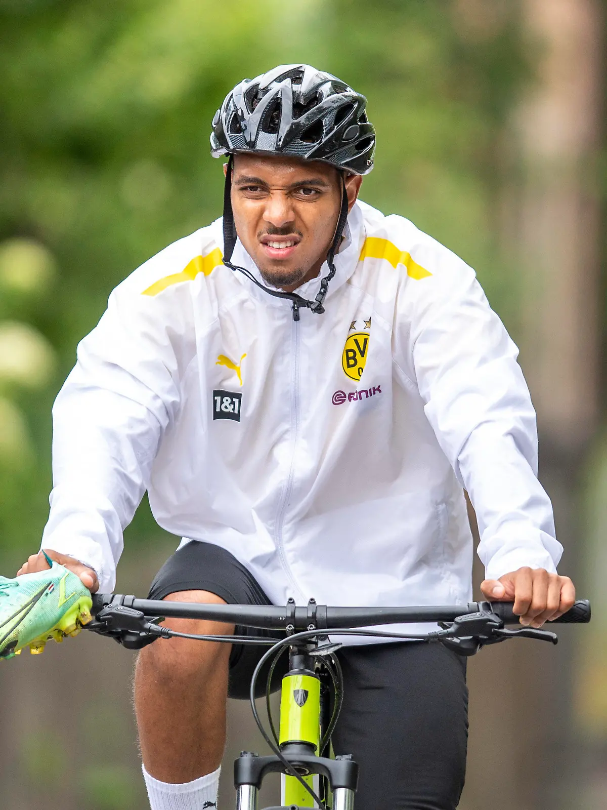 27.07.2021, Schweiz, Bad Ragaz: Fußball: Bundesliga, Trainingslager Borussia Dortmund auf dem Sportplatz Ri-Au. Donyell Malen verlässt auf einem Fahrrad das Trainingsgelände. Am Dienstagvormittag hat der niederländische Nationalspieler von der PSV Eindhoven in Bad Ragaz erstmals am Training des Fußball-Bundesligisten teilgenommen. Der 22-Jährige soll die Lücke schließen, die Jadon Sancho mit seinem 85 Millionen Euro teuren Transfer zu Manchester United hinterlassen hat. Foto: David Inderlied/dpa - WICHTIGER HINWEIS: Gemäß den Vorgaben der DFL Deutsche Fußball Liga bzw. des DFB Deutscher Fußball-Bund ist es untersagt, in dem Stadion und/oder vom Spiel angefertigte Fotoaufnahmen in Form von Sequenzbildern und/oder videoähnlichen Fotostrecken zu verwerten bzw. verwerten zu lassen. +++ dpa-Bildfunk +++